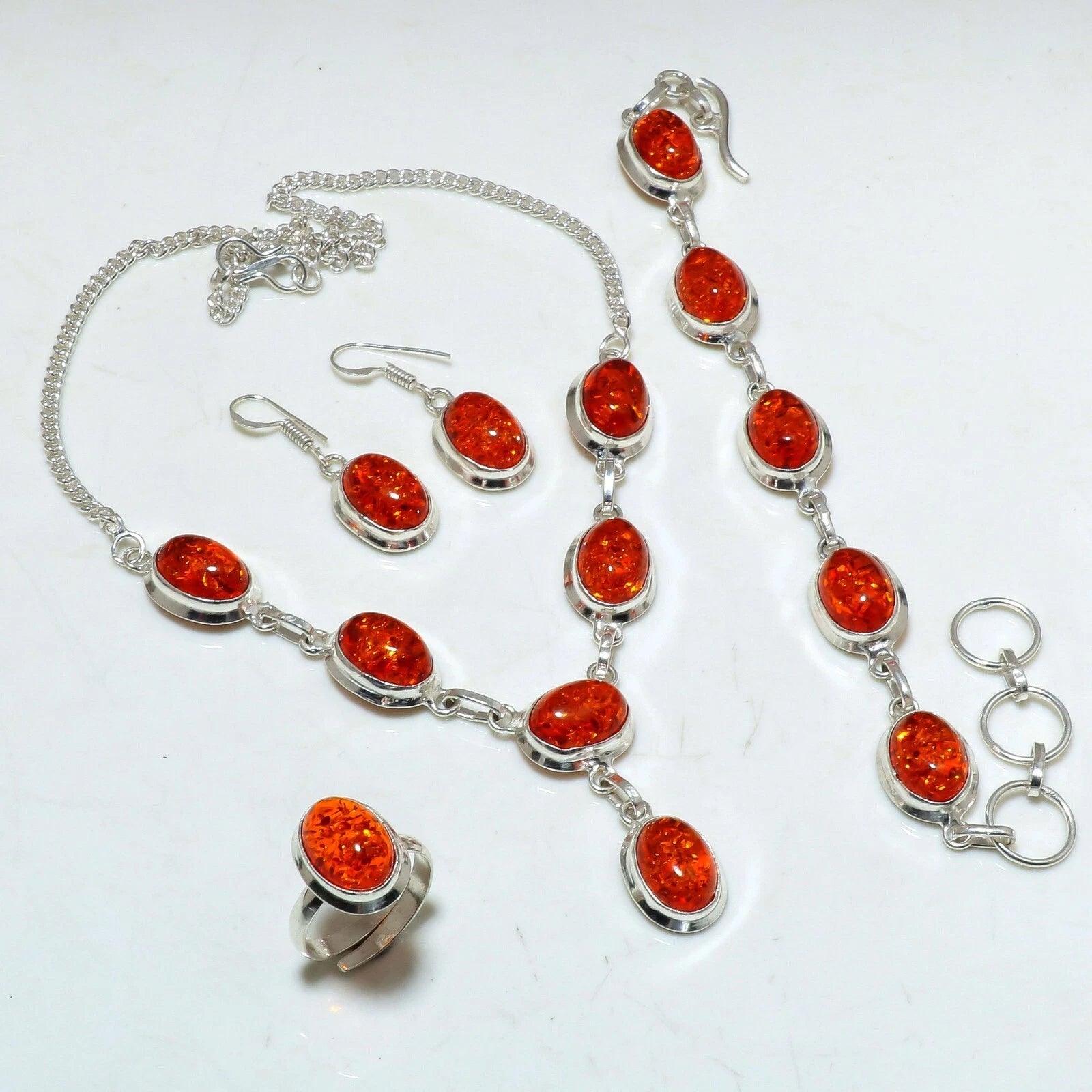 Handcrafted .925 sterling silver jewelry set with lab-created Baltic amber stones, including necklace, earrings, bracelet, and adjustable ring