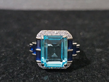 Essentials Blue Radiance ring with emerald-cut blue simulated topaz, white crystal accents, 18K white gold-plated, adjustable size L to R