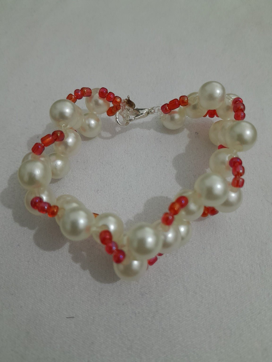 Twisted pearl-style and red glass bead bracelet with lobster clasp, vibrant and elegant dual-strand design