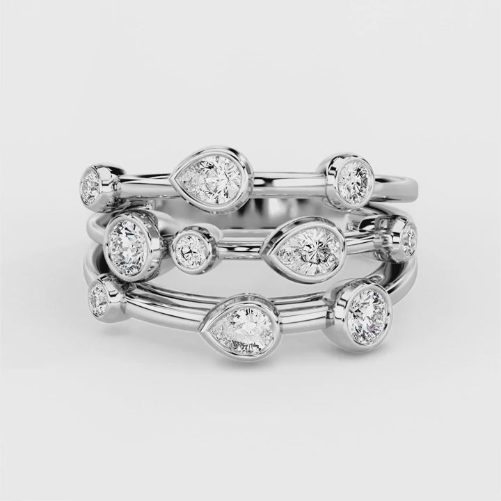 A statement diamond ring featuring rubover set pear and round diamonds