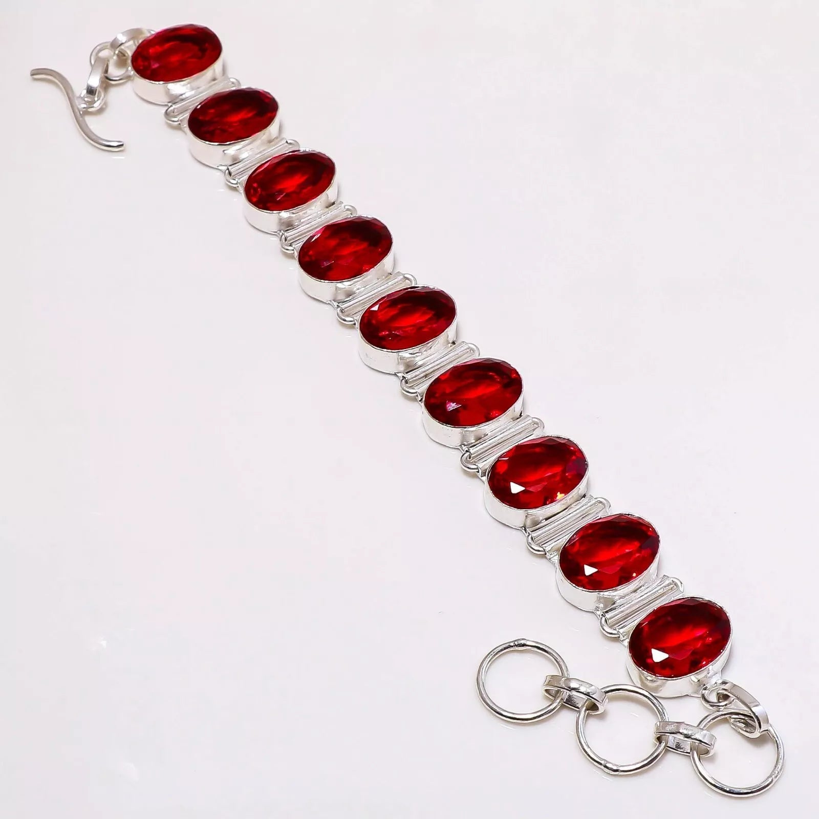 Handcrafted 925 sterling silver bracelet with nine oval-cut lab-created Mozambique garnet stones