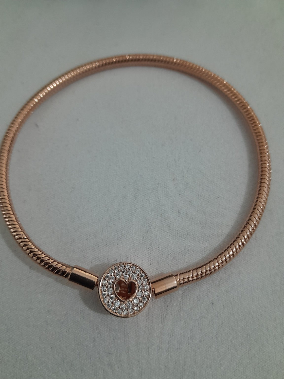 Rose-gold plated snake chain bracelet with pavé-set round heart clasp, smooth and flexible design for charms or standalone wear