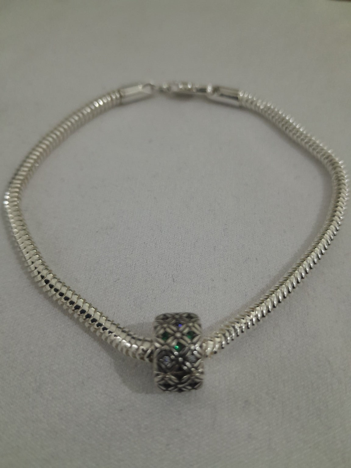 Silver-plated snake chain bracelet with filigree floral charm, green and clear crystal accents, lobster clasp, elegant everyday wear