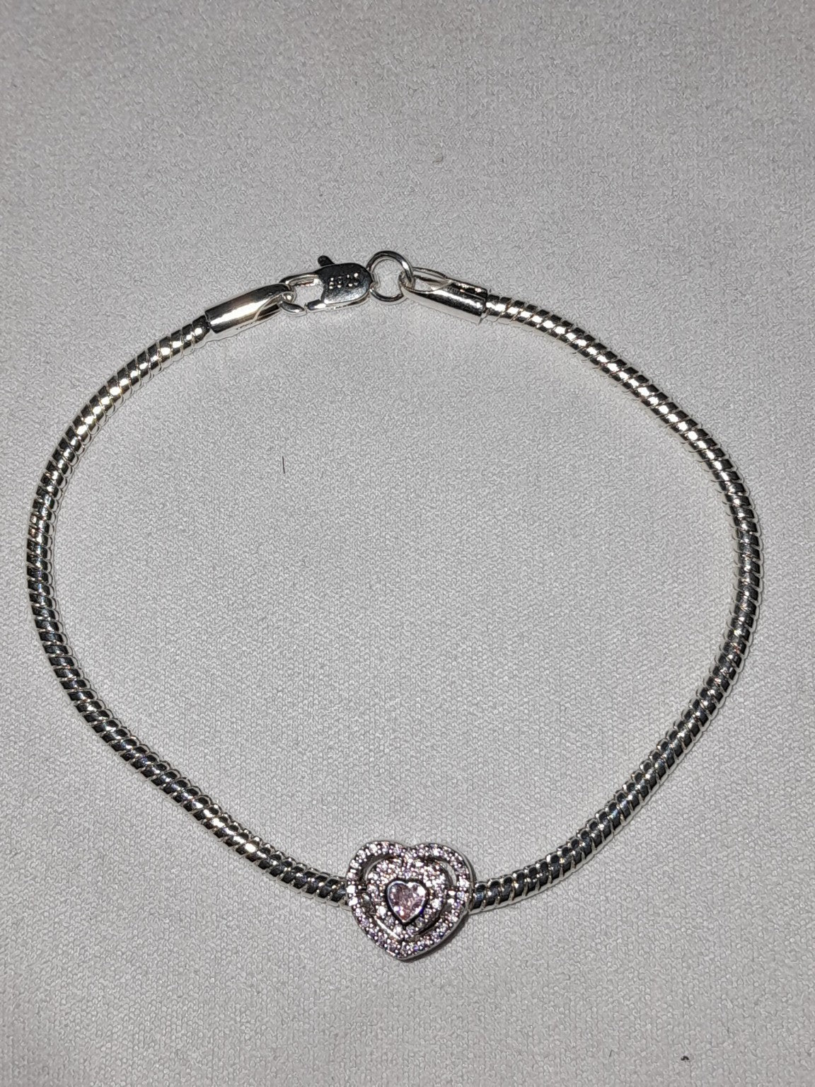 Premium sterling silver bracelet with double-layer heart charm, pavé clear stones, and light pink heart-shaped crystal